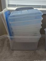 stack of clear totes with blue lids inside larger clear tote