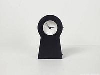 Front view showing keyhole silhouette, white dial, black numerals and hands