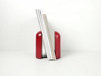 Both red arched bookends standing with sample books for scale
