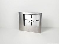 Front view of stainless steel desk clock showing dial and markers