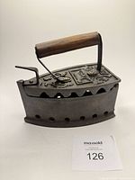 Profile of charcoal iron showing decorative lid with wood handle