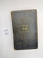 Front cover of Bible lying flat, shows gilt title and black embossed cloth