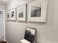 Four framed photos hung on wall with book displayed below