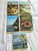 Top view of all five hardcover travel books arranged on white surface