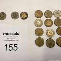 All 18 coins front sides visible next to lot tag 155