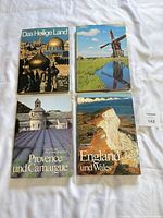 All four German travel photography books laid out: Das Heilige Land, Holland, Provence und Camargue, England und Wales
