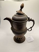 Full view of teapot with lid closed showing handle, spout, warmer base