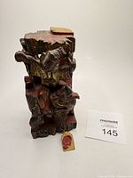 Front view of carved fragment showing figure, creature, and red wax seal tag