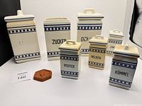 Full group showing seven labeled canisters and terracotta disc