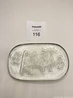 Top view of glass plate showing cow and floral relief