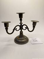 Front view of pewter three-arm candelabra showing overall form and finish