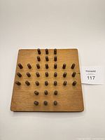 Top view of square wood board populated with pegs