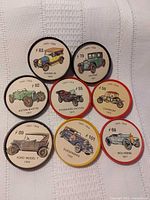 Front view showing all eight tokens with automobile illustrations and numbers