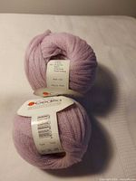 Two lavender Gedifra yarn balls showing labels