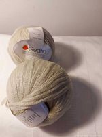 Two cream yarn balls with Gedifra Organza labels visible