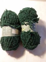 Two dark green Jarol Explorer yarn balls with labels