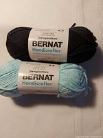 Front view of two Bernat Handicrafter yarn balls showing labels and colours