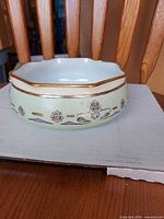 Side view showing floral motif and gold rim