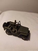 Top angle of olive drab die-cast Jeep with driver figure and spare tire