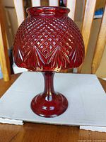 Full view of ruby red glass tealight lamp showing shape and size
