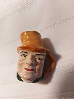 Front view of porcelain character mug showing facial detail and top hat