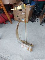 Full view of brass sailboat sculpture standing on marble base