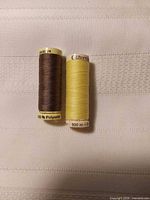 Front view of two Gutermann spools showing thread colors and labels