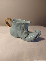 Full view of boot-shaped pitcher with handle and mouse