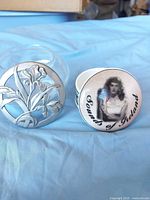 Glass trinket jar with pewter iris lid beside ceramic "Sounds of Ireland" box