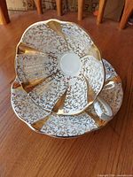 Teacup nested in saucer showing interior gold lace pattern