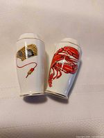 Shakers side-by-side showing lobster and creel designs