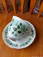 Cup and saucer set angled view showing floral pattern and gilding