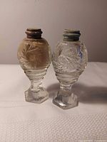 Pair of cut crystal salt and pepper shakers standing side by side
