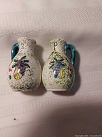 Front view of both shakers showing fruit motif and S/P letters