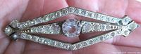 Full view of rhinestone bar brooch on hand