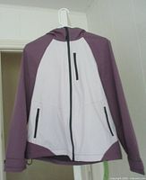 Jacket front view showing color blocking, hood, zippers