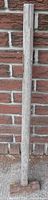 Full view of sledge hammer leaning against brick wall
