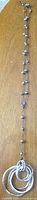 Full view of long necklace showing cord, beads, and pendant