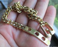 Full view of gold tone chain bracelet showing buckle clasp and adjustment holes
