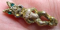 Front view highlighting tiki god form and rhinestone eyes