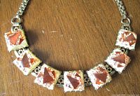 Front view of necklace showing seven square lucite stones and metal links