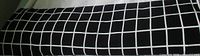 Rolled length of black fabric with white grid