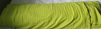 Full bolt of pale lime green fabric rolled