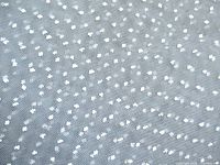 Close-up of sheer grey fabric showing white flowerhead dot pattern
