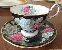 Cup on saucer showing exterior floral design and gold trim