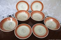 Eight pieces arranged showing bowl and plate mix with central motif and band