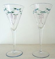 Two clear hand painted trumpet champagne flutes upright side by side