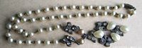 Necklace laid out showing pearl strand and filigree pendant details
