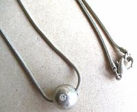 Close-up of bead pendant, snake chain and lobster clasp