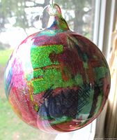 Side view of ornament showing multicolour iridescent pattern and hanging loop
